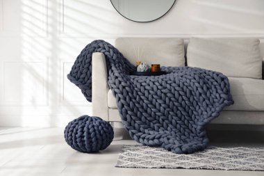 Oturma odasındaki kanepede yumuşak, tombul örgü battaniye. İç tasarım