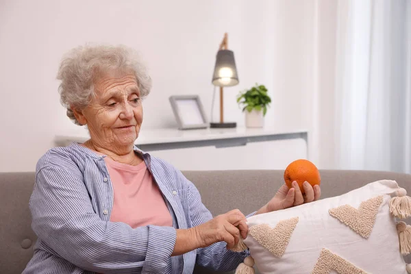 Mujer Mayor Encontrando Naranja Sofá Casa Trastorno Memoria Relacionado Con —  Fotos de Stock