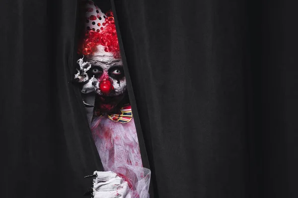 可怕的小丑躲在黑色窗帘后面 文字的空间 万圣节派对服装 — 图库照片