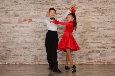 Stüdyoda dans eden iki güzel giyimli çocuk.