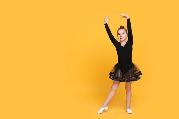 Linda Niña Vestido Negro Bailando Sobre Fondo Amarillo Espacio Para — Foto de Stock