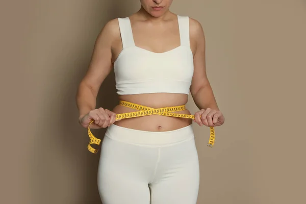 Vrouw Meten Taille Met Tape Beige Achtergrond Close — Stockfoto