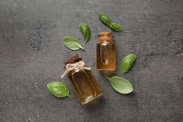 Bottles Essential Basil Oil Fresh Leaves Grey Table Flat Lay — Stock Photo, Image