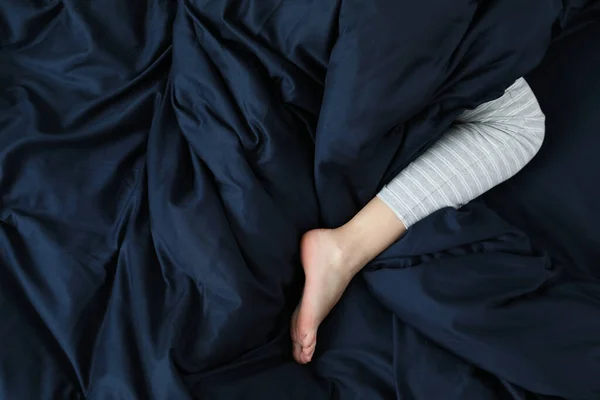 Woman Sleeping Comfortable Bed Dark Blue Linens Closeup Leg — Stock Photo, Image