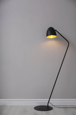 Açık gri duvarın yanında modern zemin lambası, yazı için yer var. İç öge