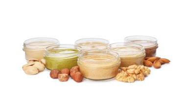 Beyaz arka planda farklı fındıklardan yapılmış tereyağlı kavanozlar.