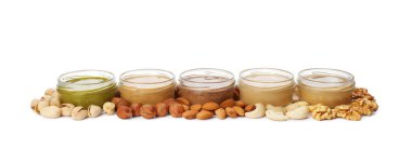 Beyaz arka planda farklı fındıklardan yapılmış tereyağlı kavanozlar.