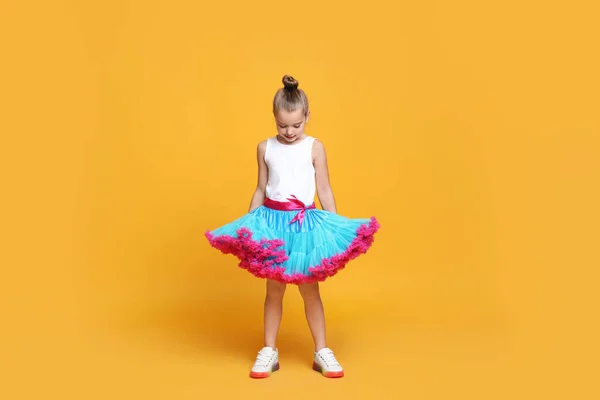 Sarı Arka Planda Dans Eden Etekli Tatlı Küçük Kız — Stok fotoğraf