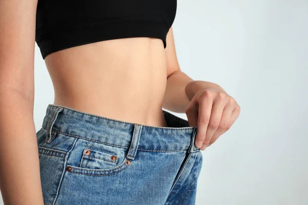 Skinny Woman Oversized Jeans Light Background Closeup Weight Loss Concept — Stock Photo, Image