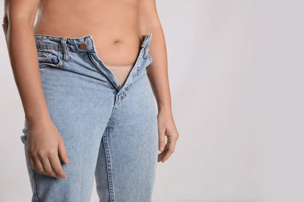 Vrouw Ongeschikte Jeans Lichte Achtergrond Close Ruimte Voor Tekst — Stockfoto