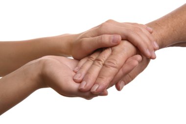 Beyaz arka planda el ele tutuşan genç ve yaşlı kadınlar, yakın plan.