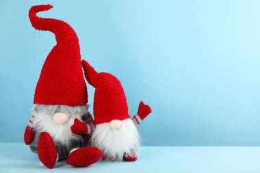 Açık mavi arka planda iki sevimli Noel cücesi. Metin için boşluk