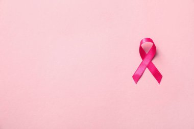 Renk arkaplan üzerine pembe kurdele, metin için boşluk ile üst görünüm. Göğüs kanseri farkındalığı konsepti