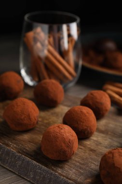 Tahta tahtada kakao ile pudralanmış lezzetli çikolatalı mantarlar, yakın plan.