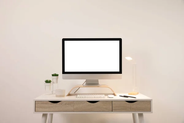 舒适的工作场所 光墙附近的桌子上有空白的计算机显示 案文的篇幅 — 图库照片
