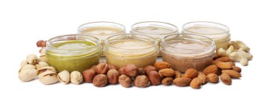 Beyaz arka planda farklı fındıklardan yapılmış tereyağlı kavanozlar.