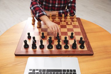 Kadın eşiyle satranç oynuyor çevrimiçi görüntülü sohbet masası içinde, yakın plan.
