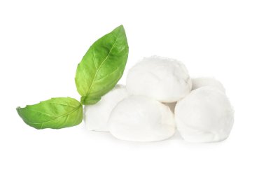 Lezzetli mozzarella peynir topları ve beyaz arka planda fesleğen.