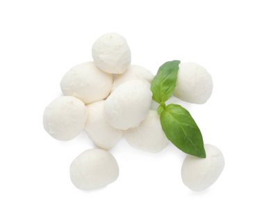 Beyaz arka planda mozzarella peyniri topları ve fesleğen yığını.