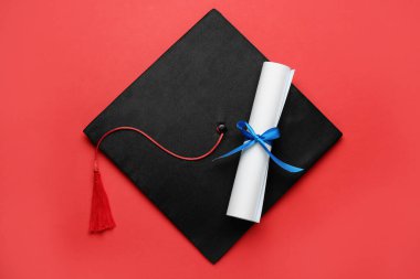 Mezuniyet şapkası ve diploması kırmızı arka plan, üst görünüm
