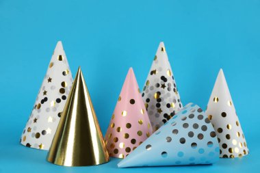 Açık mavi arka planda parlak parti şapkaları