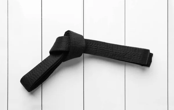 Gebundener Schwarzer Gürtel Auf Weißem Holzhintergrund Draufsicht Orientalische Kampfkunst — Stockfoto