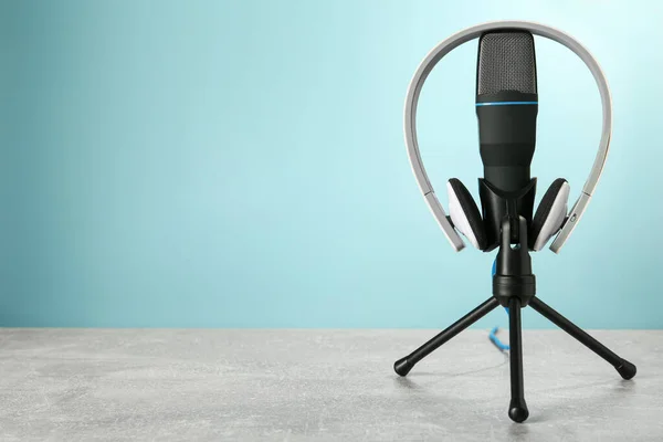 Micrófono Auriculares Modernos Sobre Mesa Gris Sobre Fondo Azul Claro —  Fotos de Stock