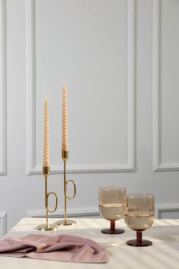 Beyaz masada, mumların yanında şarap kadehleri