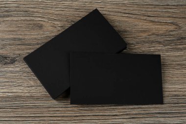 Tahta arka planda boş siyah kartvizitler, düz yatış. Tasarım için model