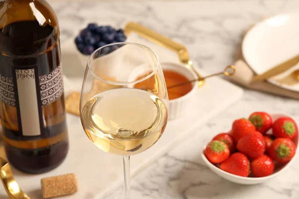 ボトルの近くのワインのグラスと白いテーブルの上のおいしい軽食 クローズアップ — ストック写真