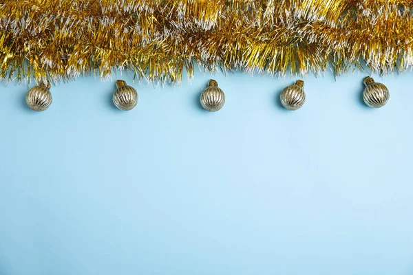 明るい青の背景に金色のティンセルとクリスマスボール フラットレイアウト テキストのスペース — ストック写真