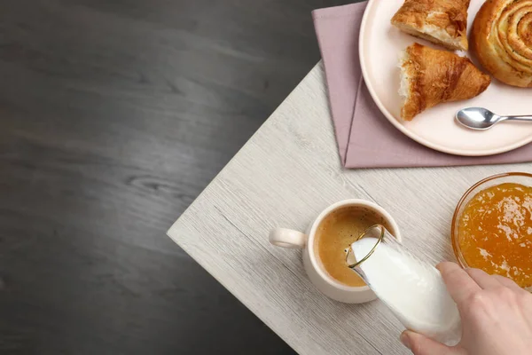 Mujer Vertiendo Leche Taza Con Café Pastelería Mesa Madera Vista — Foto de Stock