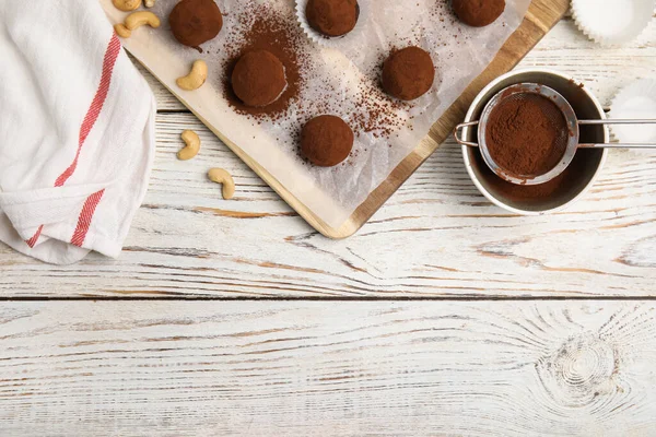 美味的巧克力松露与可可粉和坚果放在白色木制桌子上 案文的篇幅 — 图库照片