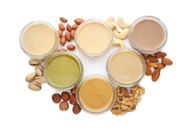 Beyaz arka planda farklı fındıklardan yapılmış tereyağlı kavanozlar, üst görünüm