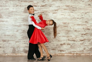 Stüdyoda dans eden iki güzel giyimli çocuk.