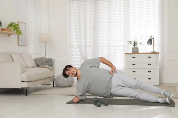 Υπέρβαρος Άνθρωπος Κάνει Πλευρική Σανίδα Άσκηση Στο Χαλί Στο Σπίτι — Φωτογραφία Αρχείου