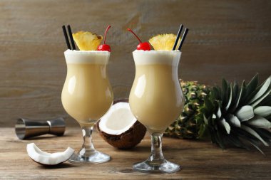 Lezzetli Pina Colada kokteyli ve ahşap masa malzemeleri.
