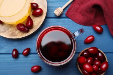 Düz kompozisyon, mavi ahşap masa üzerinde taze kızılcık çayı ve böğürtlen.