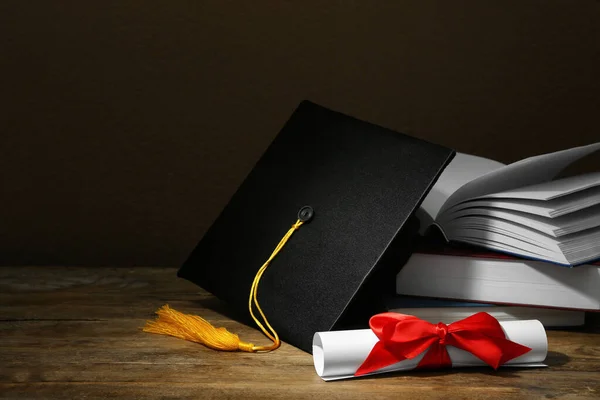 Mezuniyet Şapkası Kitaplar Diploma Ahşap Masa Üzerinde Kahverengi Arka Plan — Stok fotoğraf