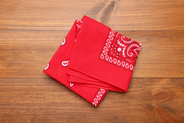 木制桌子上的折叠式红色手帕 顶部视图 — 图库照片
