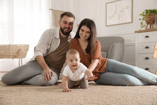 Gelukkig Ouders Kijken Naar Hun Baby Kruipen Vloer Thuis — Stockfoto