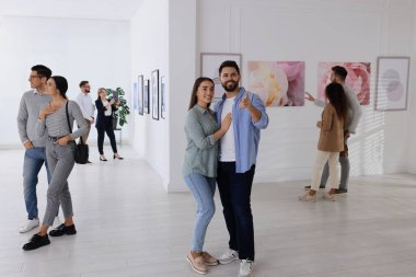 Modern sanat galerisinde sergi ile ilgilenen insanlar