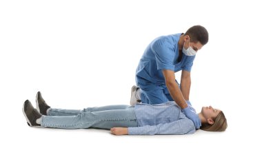 Üniformalı doktor beyaz arka planda kadınlara ilk yardım uyguluyor.