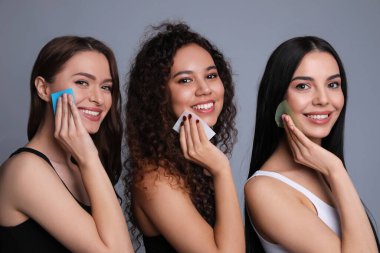 Gri arka planda eşleşen mendil kullanan güzel kadınlar