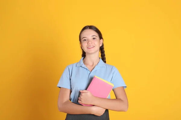 Teenage Dívka Školní Uniformě Knihami Oranžovém Pozadí — Stock fotografie