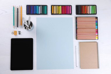 Boş kağıt, yumuşak pasteller ve sanatçının işyerindeki beyaz ahşap masaya çizim malzemeleri, üst manzara. Tasarım için boşluk