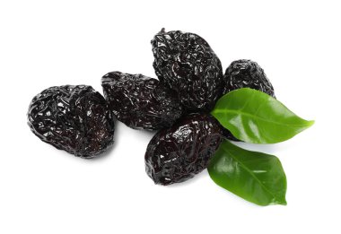 Beyaz arka planda kurumuş kuru erik ve yeşil yapraklar yığını.