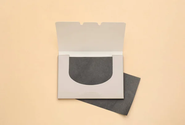 Facial oil blotting tissues on beige background, flat lay. Mattifying wipes