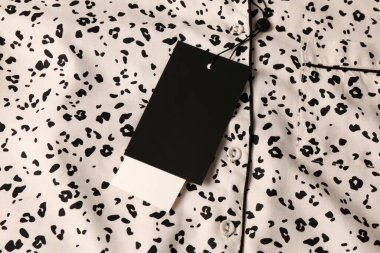 Üzerinde hayvan izi olan beyaz pijama gömleğinde boş etiketler. Metin için boşluk