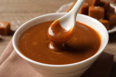 Lezzetli karamelli ve kaşıklı masayı alıyorum, yakın plan.